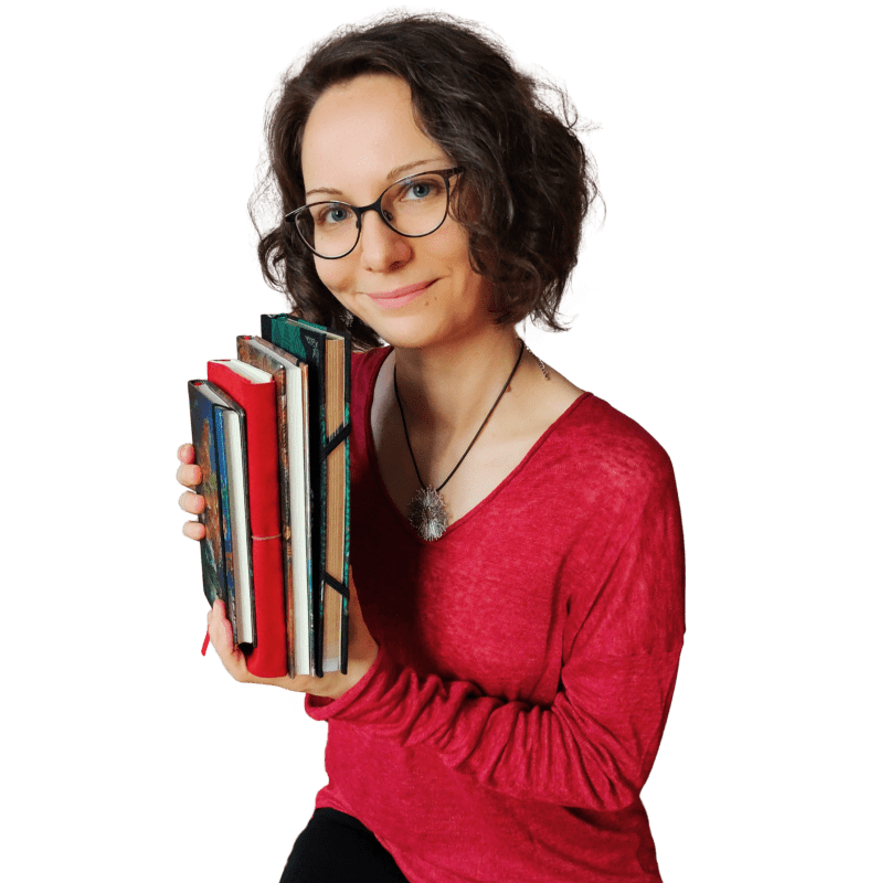 Frau mit vier Notizbüchern in der Hand.