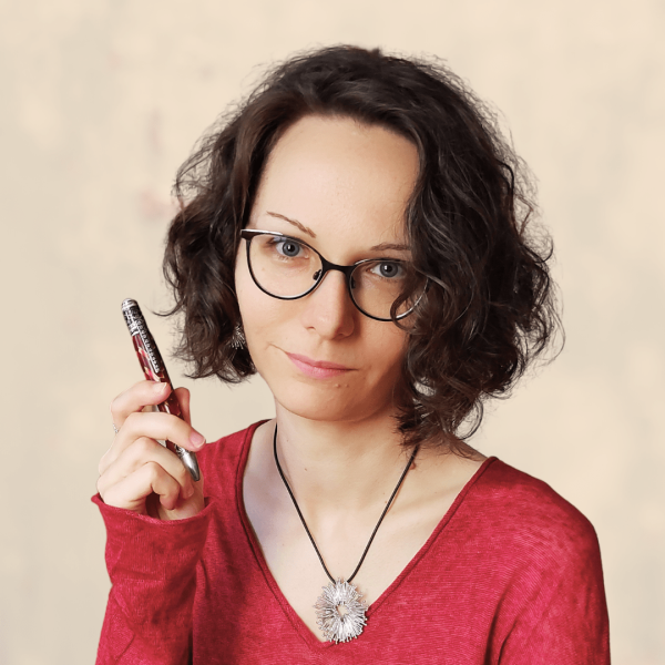 Portraitfoto der Autorin. Lächelnde Frau mit kurzen gelockten Haaren und Brille.