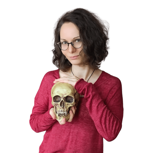 Frau mit Brille und Deko-Totenschädel in der Hand.